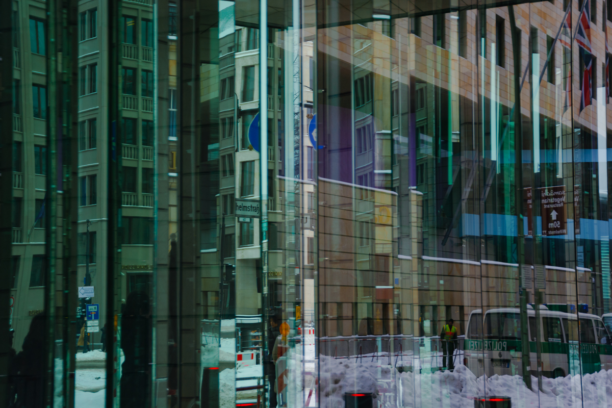 Spiegelnde Glasfassaden und überlagerte Architektur in einer Berliner Seitenstraße im Winter
